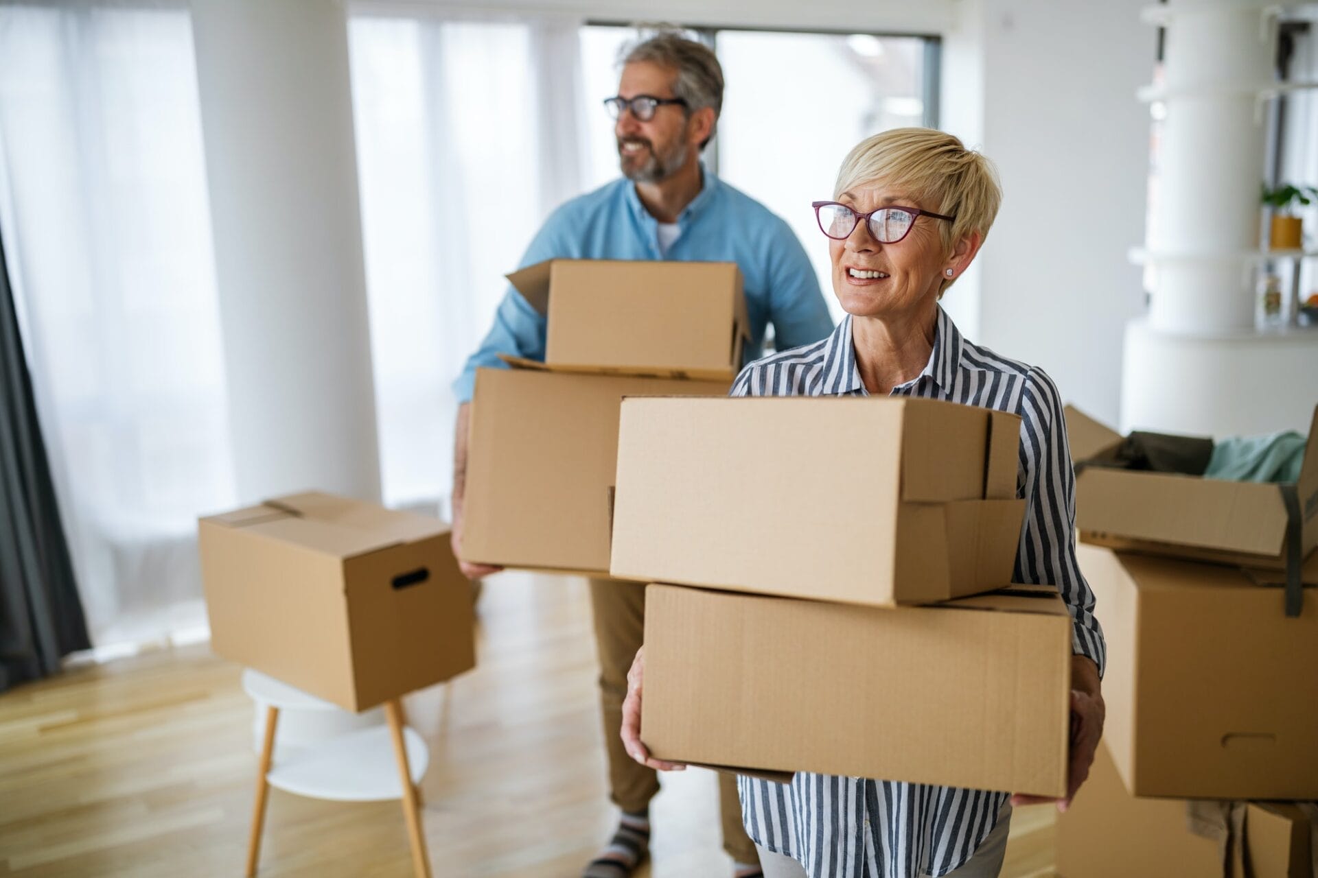 Happy retired senior couple moving into a new home, apartment